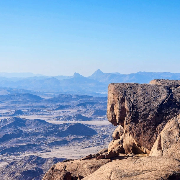 A scenic mountain view from the top of Mount El-Banat, showing the vast terrain of South Sinai during a trekking adventure