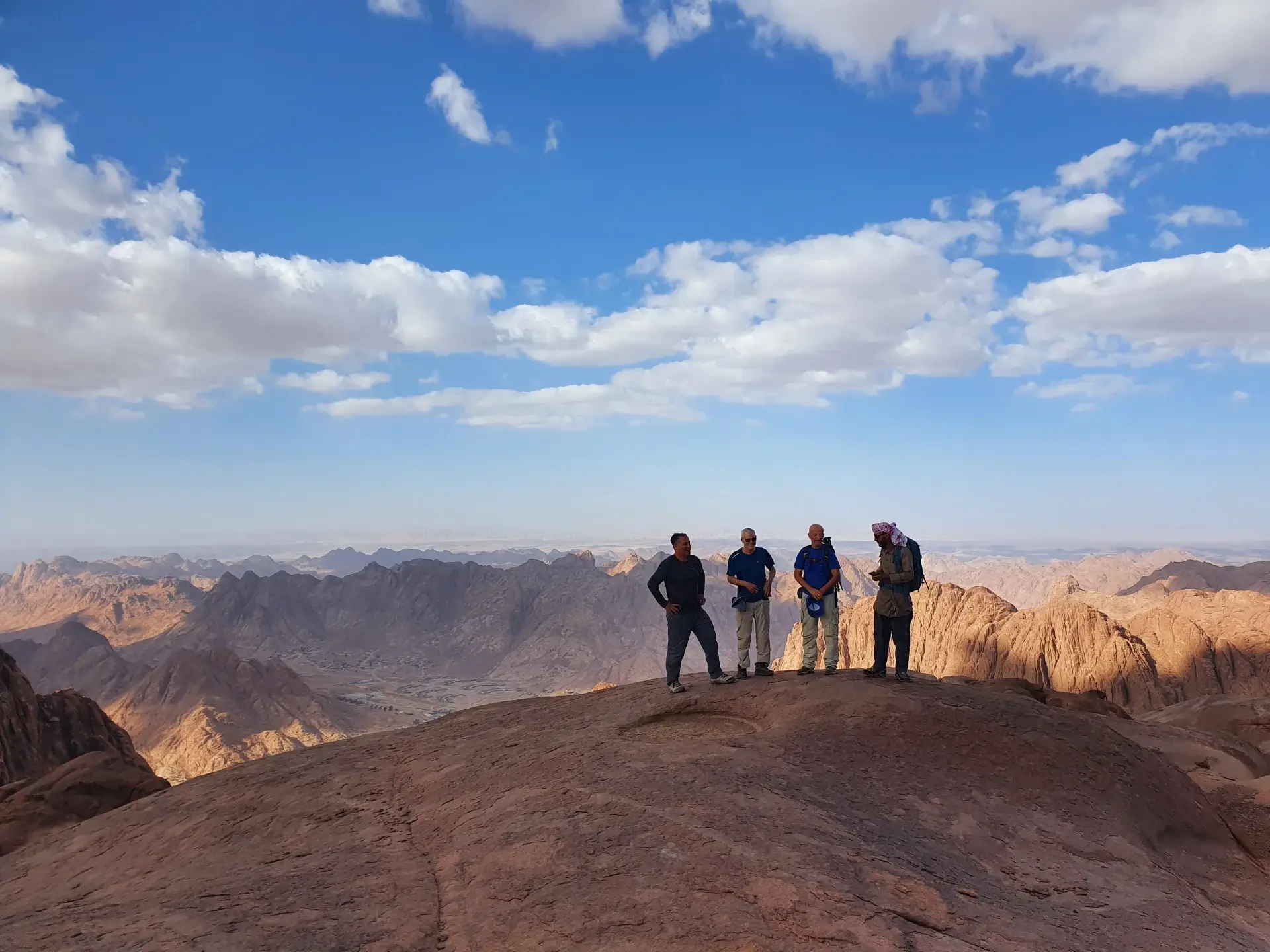 A group of hikers following a Bedouin guide while climbing Mount Ahmar during a Sinai trekking adventure