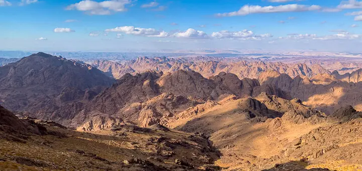 View from Mount Catherine with soft sunlight breaking through clouds over the Sinai Mountains.
