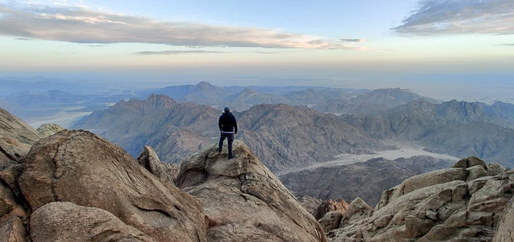 Hiker on the summit of Mount Shayib El Banat during golden hour, Eastern Desert, Egypt Mountains.