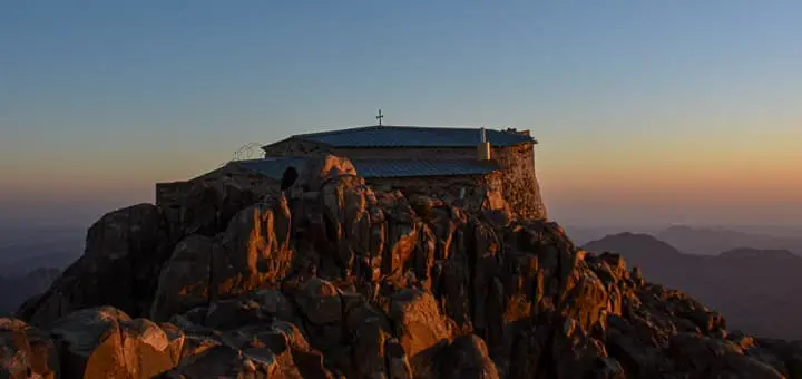 Stone chapel on the summit of Mount Catherine in South Sinai, Egypt, lit by soft morning light with rugged Egypt Mountains in the background.