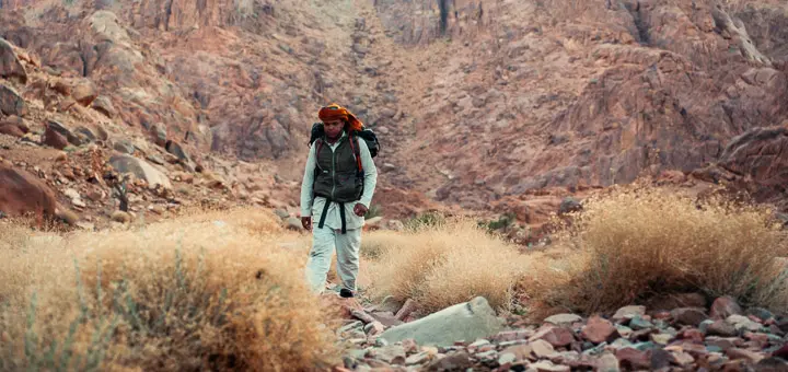 Bedouin guide walking through rocky valleys on the way to Mount Serbal in the Egypt Mountains.
