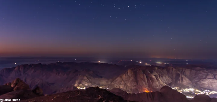 The Sinai Mountains under a star-filled night sky viewed from a high mountain peak.