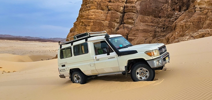 4x4 jeep stopped among sand dunes during a Sinai Desert safari